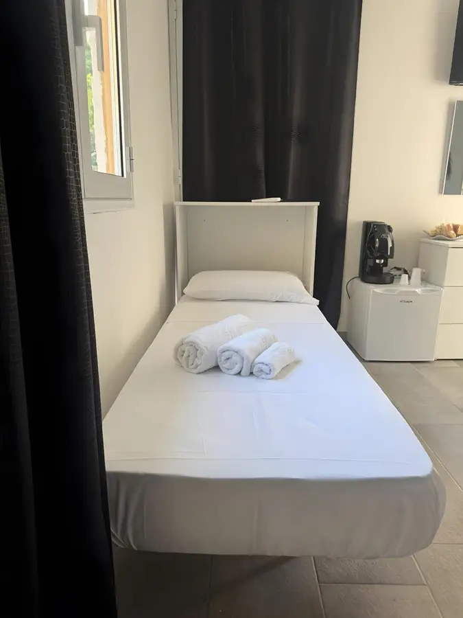 Letto singolo accanto alla macchina del caffè